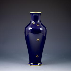 Vaso com fundo azul e flocos de neve dourados
